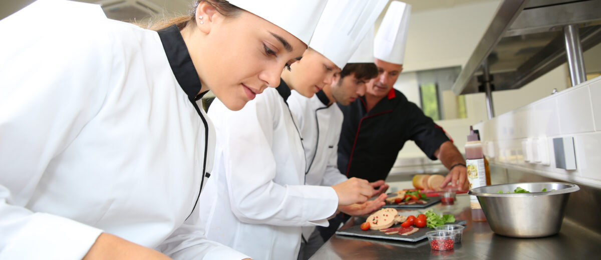 Team of young chefs preparing delicatessen dishes